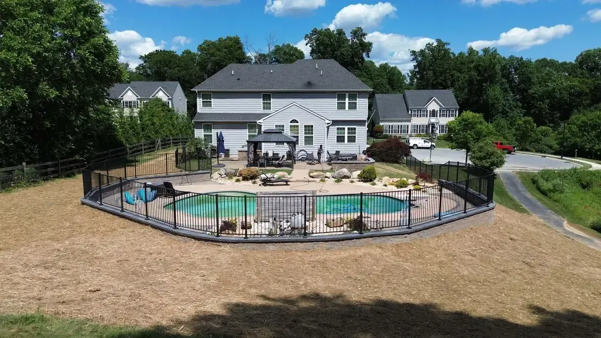 Backyard pool with gazebo stamped concrete deck and aluminum fencing in Chester County PA