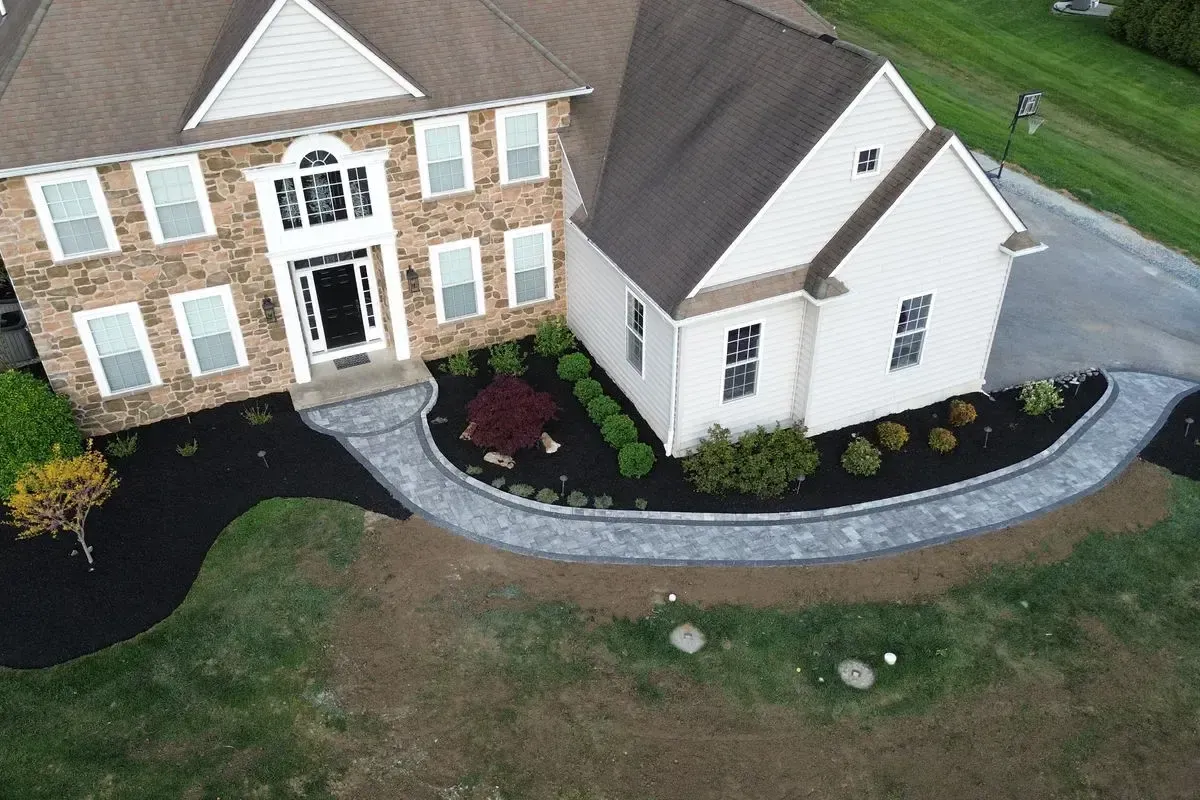 Aerial view of curved front walkway with landscaping on stone facade home Chester County PA