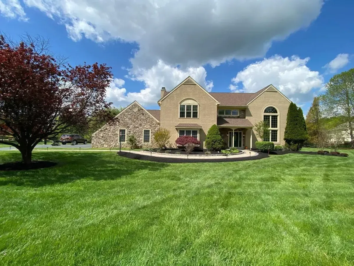 Luxury front yard landscaping with curved paver walkway and mulch beds in Chester County PA