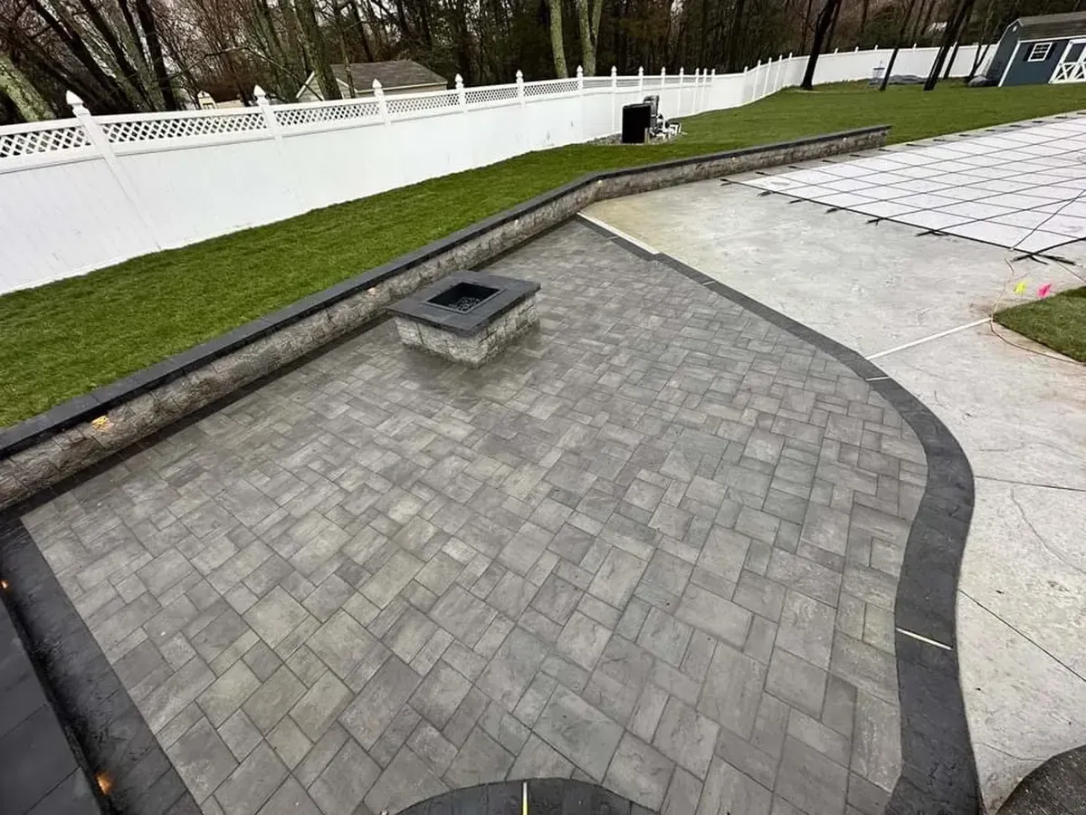 Paver patio with fire pit and natural stone retaining wall with lighting in Chester County PA